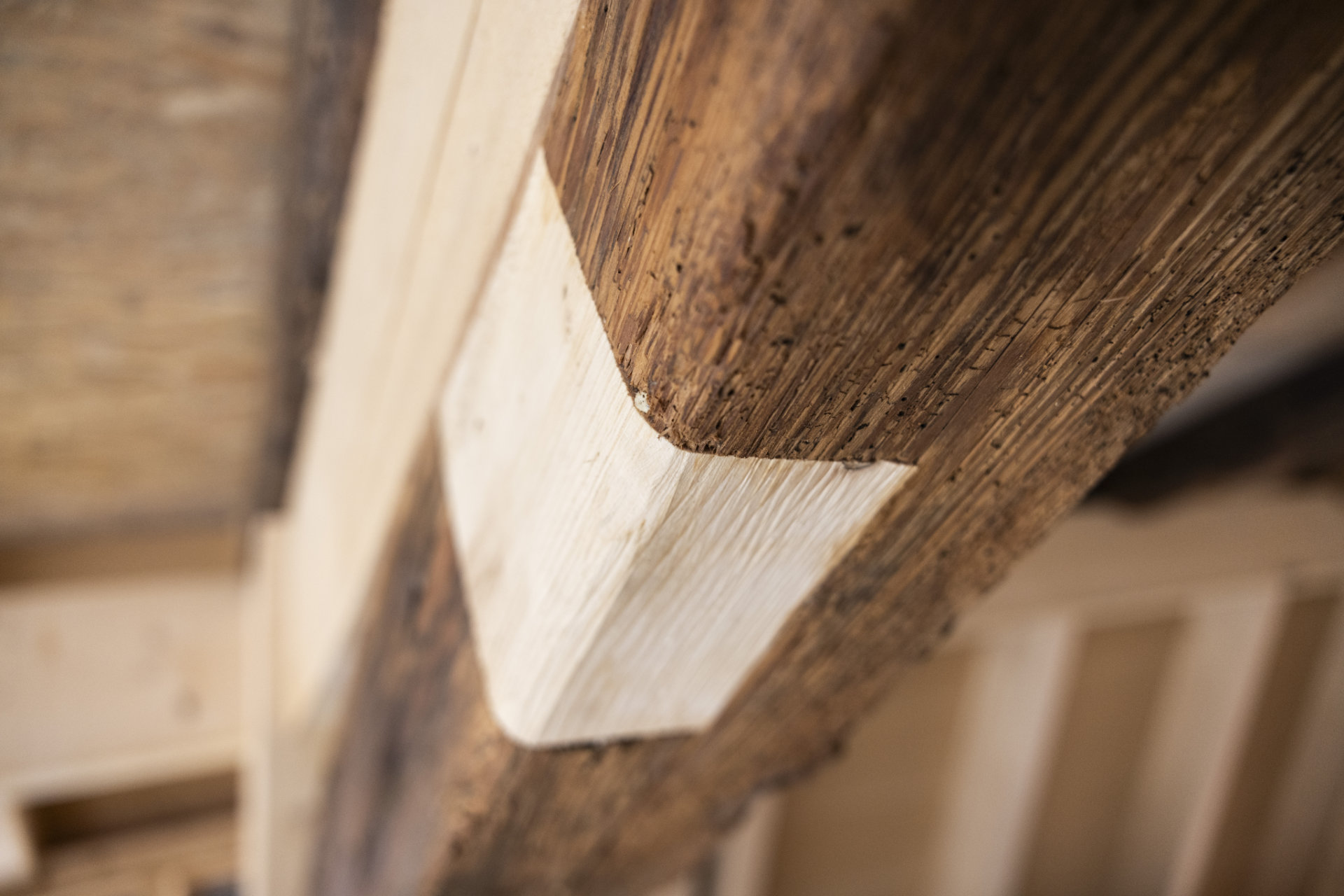Restaurierung mit Holz Ein antiker Holzbalken wird mit neuem Holz restauriert.